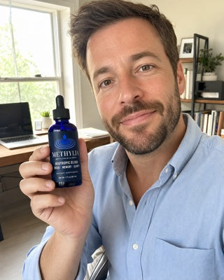 Derick holding a bottle of Methylia in his home office