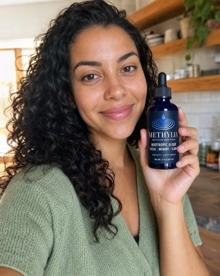 Melissa holding a bottle of Methylia in her kitchen