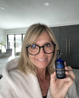 Sarah holding a bottle of Methylia at home