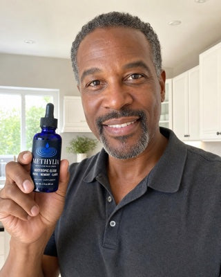 Tony holding a bottle of Methylia in his kitchen
